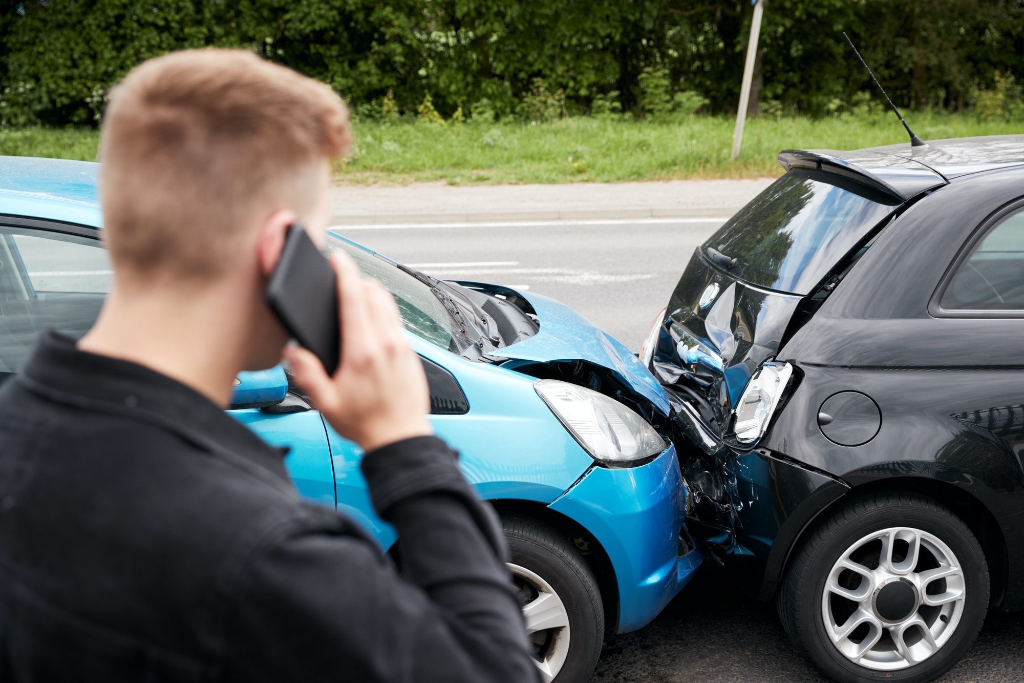 young-male-motorist-involved-in-car-accident-calling-insurance-company-or-recovery-service.jpg