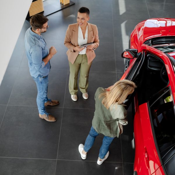 couple-choosing-and-buying-car-at-car-showroom-car-saleswoman-helps-them-to-make-right-decision-.jpg